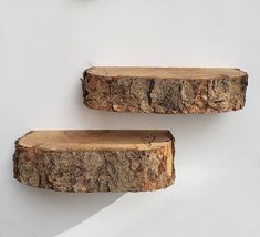 two pieces of wood sitting on top of each other in front of a white wall