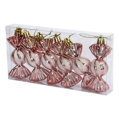 pink glass ornaments in a clear box with gold trimmings on the top and bottom