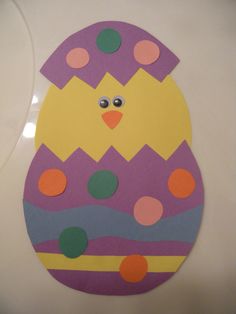 an easter egg painted with colorful dots and a yellow chick on it's back