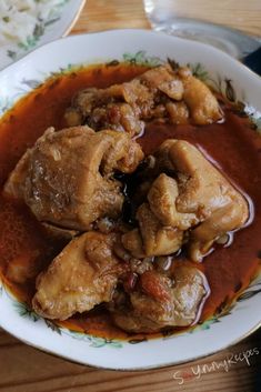 a white plate topped with meat covered in gravy