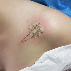 a small flower tattoo on the back of a woman's stomach