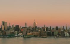 the city skyline is lit up at sunset