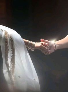 the bride and groom are holding hands with each other