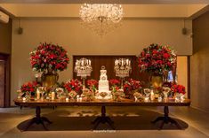 a table with flowers and candles on it in front of a chandelier that is hanging from the ceiling