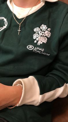 a person wearing a green sweatshirt and white gloves