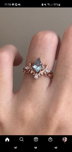 a woman's hand holding a ring with an aqua blue topazte and white diamonds