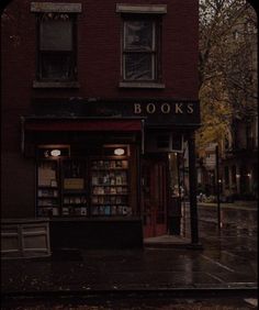 a book store sitting on the side of a road in the rain with its lights on