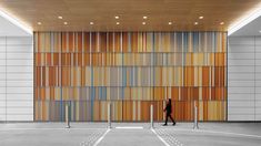 a person standing in front of a wall made out of wood and metal bars,