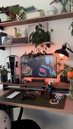 a desk with a computer and plants on it