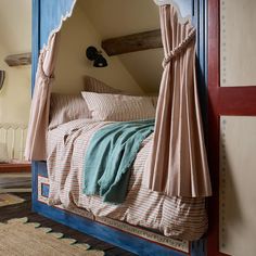 a bed with a canopy over it in a bedroom next to a rug on the floor