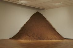 a pile of dirt sitting in the middle of a room next to a white wall