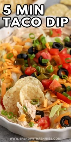 a white bowl filled with taco dip and tortilla chips on the side