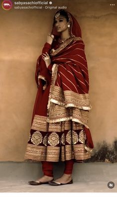 a woman in a red and gold dress with an orange shawl on her head