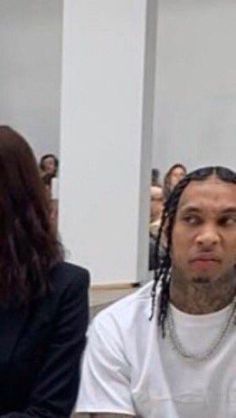 a man with dreadlocks sitting next to a woman in front of a mirror