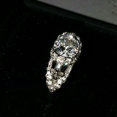 a diamond ring sitting on top of a black surface