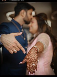 a bride and groom holding their hands out to each other