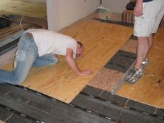 two men are laying on the floor with their feet in the air and one man is working