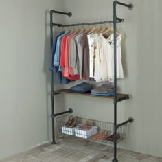 a rack with clothes and shoes on it next to a wall mounted closet rail in a room