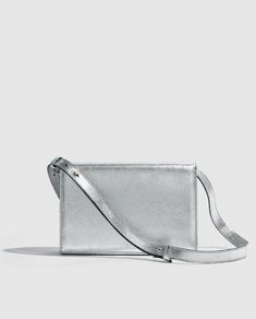 Silver metallic party bag with structured design, light and versatile. Vintage inspired.      

Made in bovine leather with metallic finish. 
Flap with magnetic clip closure.     
Adjustable and detachable long leather handle.
Open inside pocket. 
Designed and manufactured entirely in Spain using sustainable processes and small productions.
W17 cm x L25cm x D6 cm. Modern Silver Rectangular Bags, Gold Handbag, Metallic Party, Gold Handbags, Structured Design, Handbag For Women, Design Light, Party Bag, Party Bags