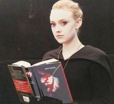 a woman is holding a book in her hands