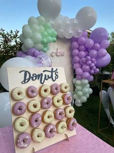 a doughnut display with balloons in the background