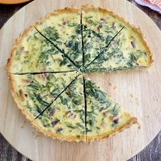 an omelet with spinach and cheese cut into four slices on a cutting board