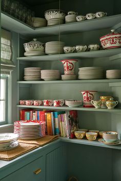 the shelves in this kitchen are filled with plates and bowls, dishes on top of them