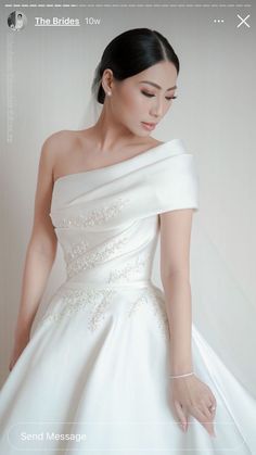 a woman in a white wedding dress is holding her hand on the shoulder and looking down