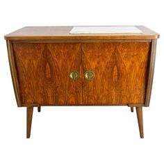 an old fashioned wooden cabinet with two doors and brass knobs on the front, against a white background