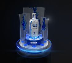 a bottle is sitting in a display case with blue lights on the bottom and sides