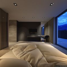 a large bed sitting in a bedroom next to a window with an outside view at night