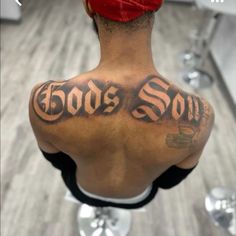 the back of a man's head with tattoos on his upper and lower back