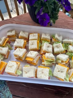 there are many small sandwiches on the tray