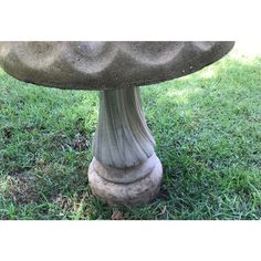 an old stone pedestal sitting in the grass