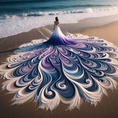 a woman is standing on the beach with a large peacock feather in front of her