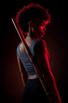 a woman holding a baseball bat in the dark