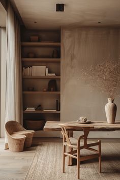 a wooden table sitting in front of a window next to a vase with flowers on it