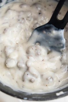 a ladle filled with cream and meat in a saucepan on a stove top