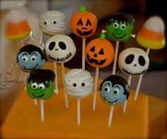 there are many halloween cake pops on the table