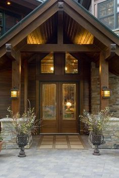 the front entrance to a home with two large planters