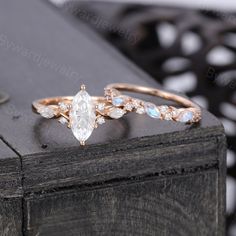 two wedding rings on top of each other with white and blue stones in the middle