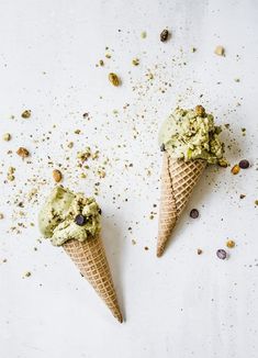 two ice cream cones with pistachio and chocolate chips