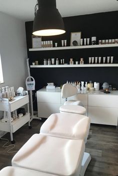 a salon room with white chairs and shelves