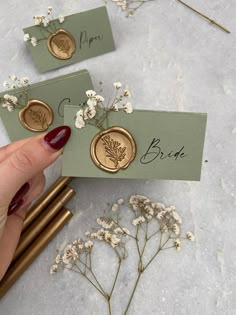 a person holding up some business cards with flowers on them and writing the word bridal