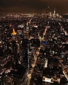 an aerial view of the city at night with lots of lights and skyscrapers lit up