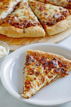 a slice of pizza sitting on top of a white plate next to other food items