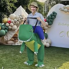 a man riding on the back of an inflatable dinosaur at a children's birthday party