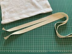 a pair of scissors next to a piece of cloth on a cutting board with a measuring tape