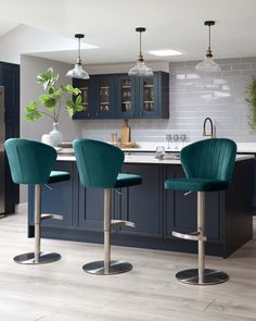 three blue chairs are in front of the kitchen island and bar stools that sit at the end of the counter