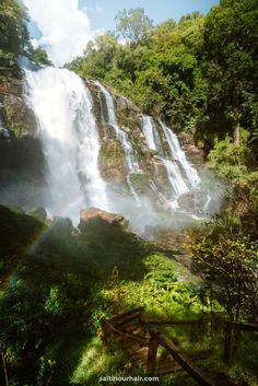 a large waterfall with a rainbow in the middle of it's water cascadings